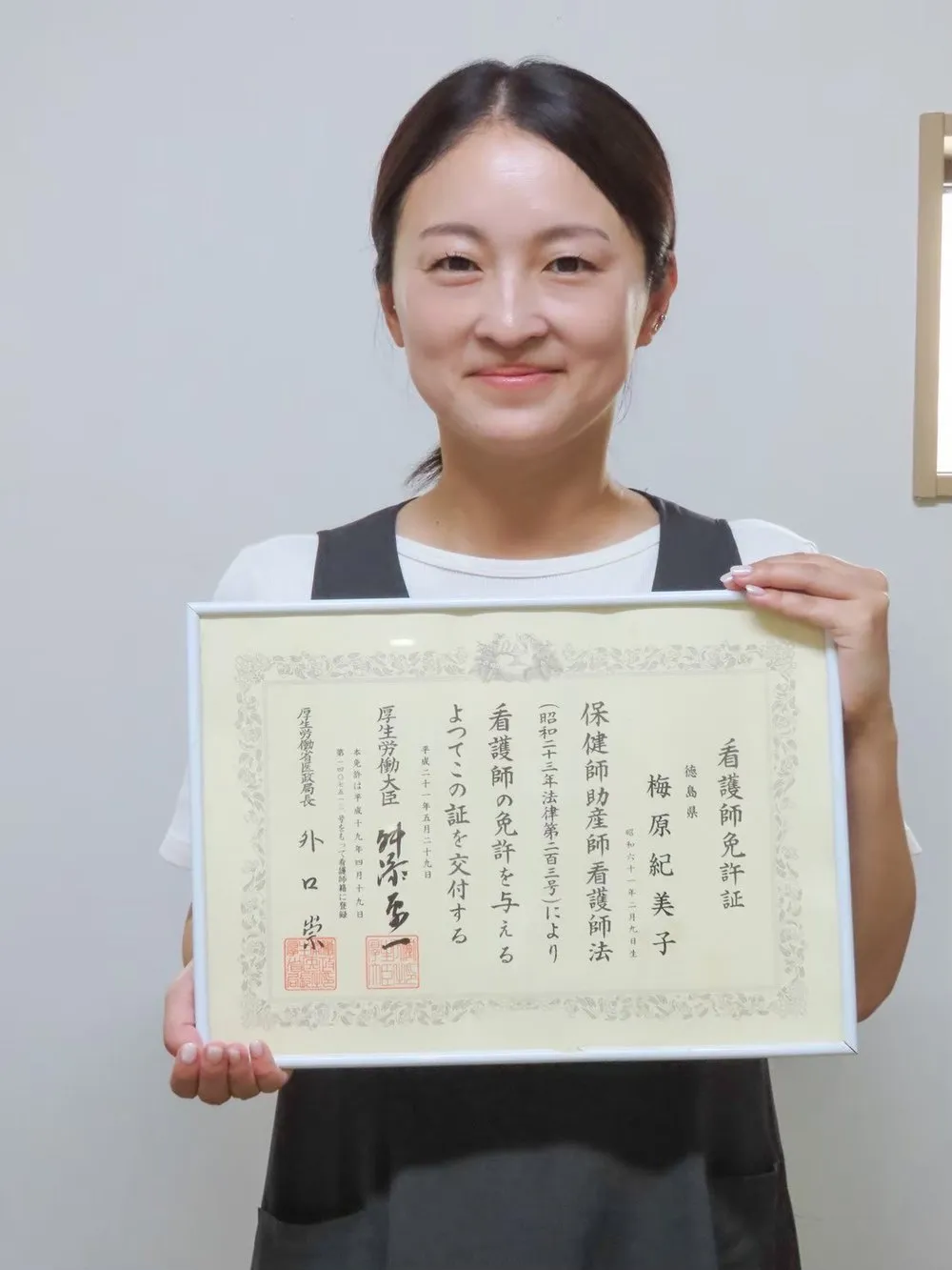 看護師免許証を手にする、施術担当スタッフ